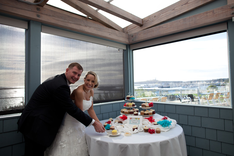 newlyweds cutting wedding cupcake