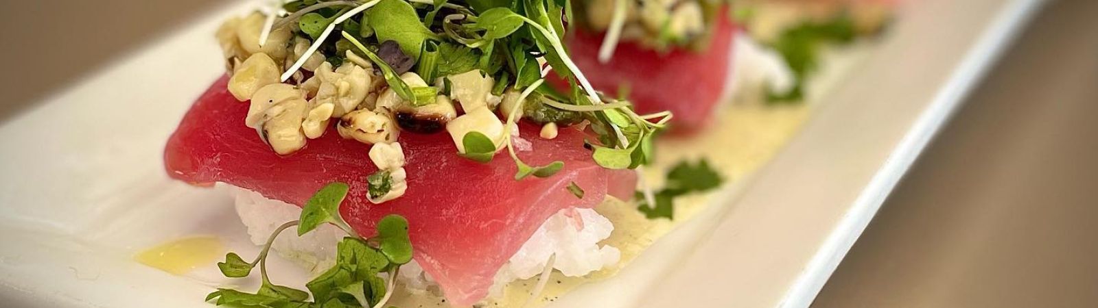 ahi sashimi over sushi rice with corn salsa and microgreens
