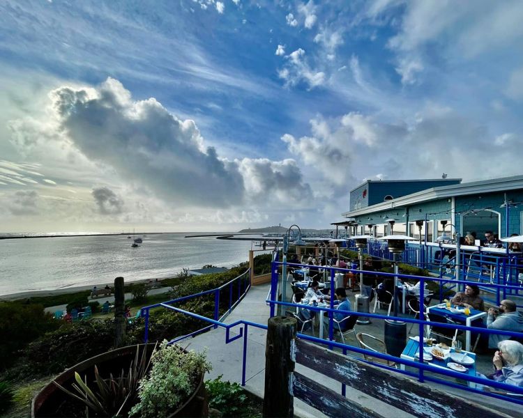 outdoor dining ocean view with dramatic clouds